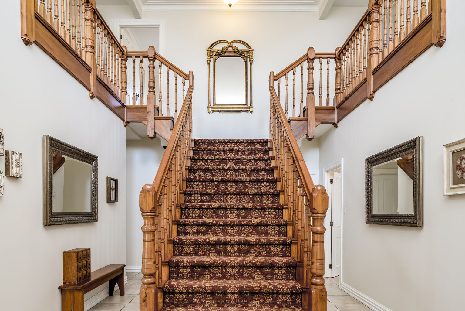 big-wooden-staircase-with-vintage-carpet-inside-apartment-with-white-walls.jpg